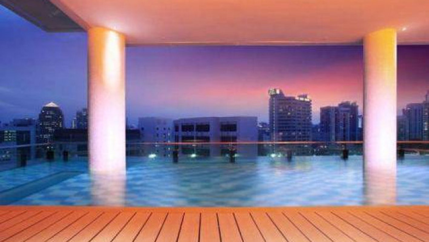 Rooftop infinity pool at Quincy Hotel Singapore at dusk, with city skyline and twilight sky