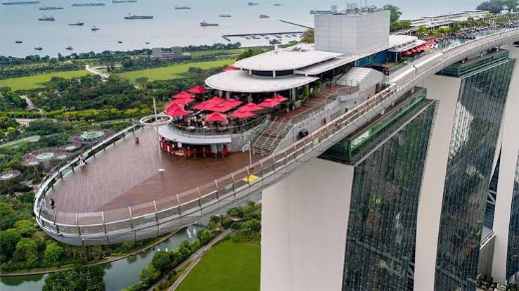 Aerial view of the Marina Bay Sands SkyPark cantilever and red umbrellas