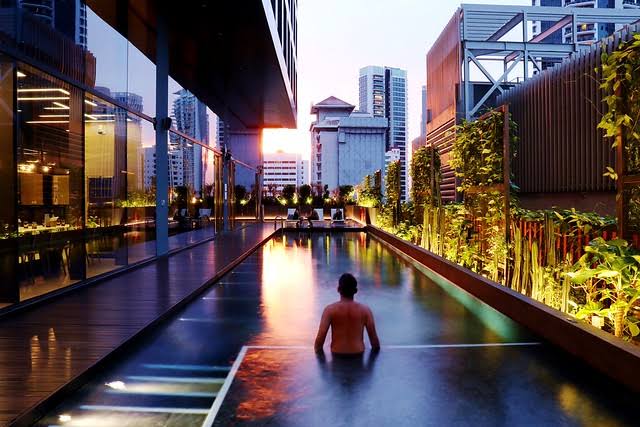 Rooftop infinity pool at Yotel Orchard overlooking the Singapore skyline at dusk